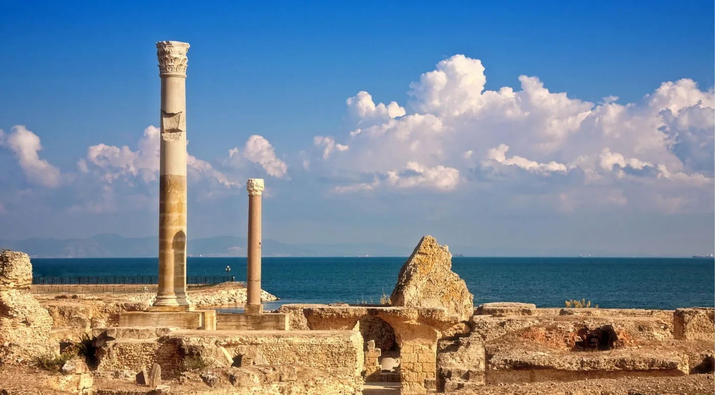 Two Roman columns standing among the Carthage ruins beside the Mediterranean