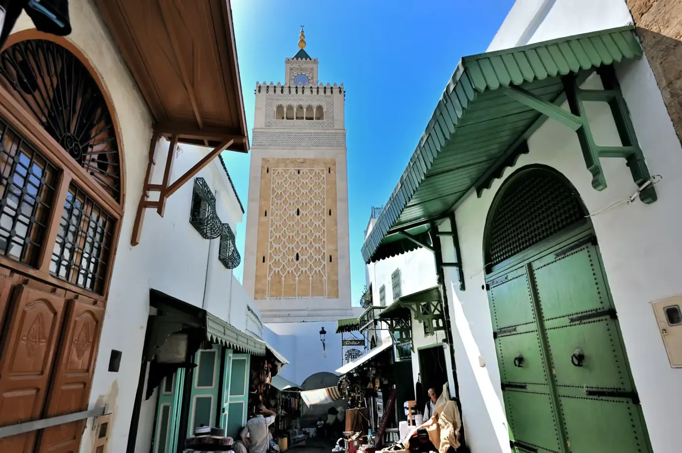 The minaret of the Zitouna Mosque above a medina street