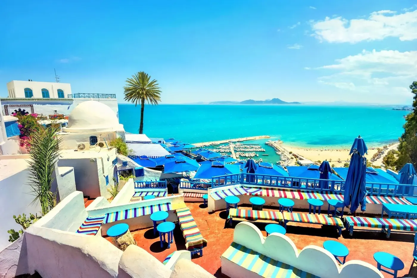 Blue parasols on a clifftop café terrace above the sea at Sidi Bou Said