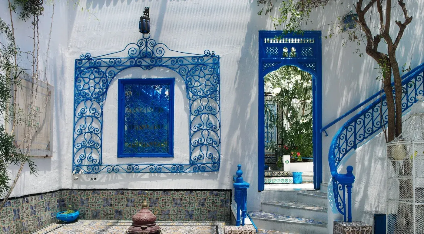 A blue-and-white tiled courtyard with wrought-iron window grilles