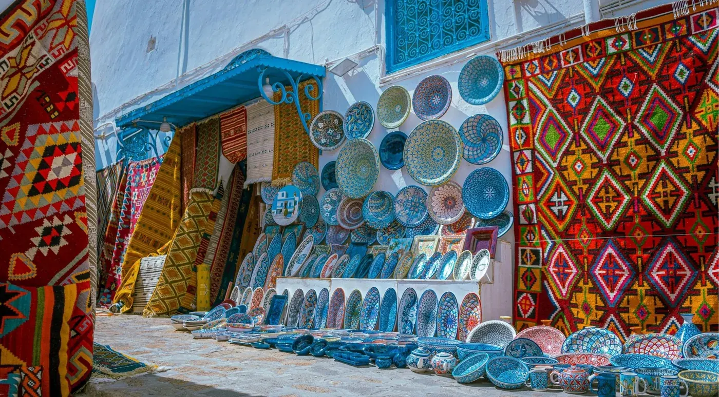 A wall of Tunisian ceramics and woven carpets in a souk