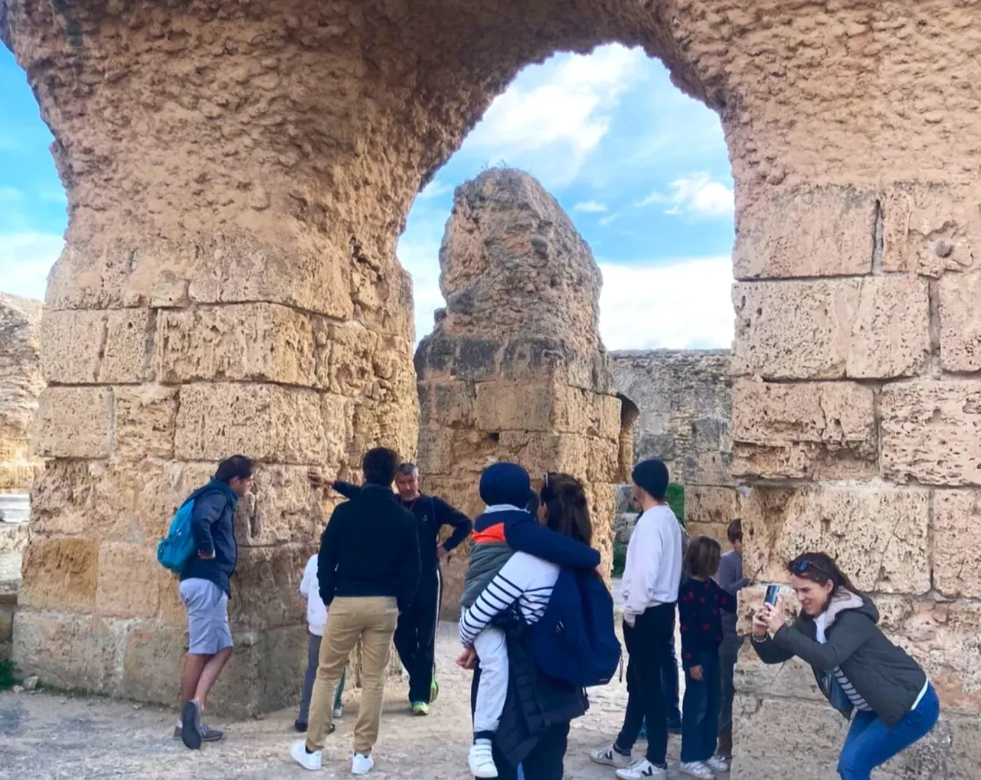 The group passing beneath a stone arch at the Antonine Baths