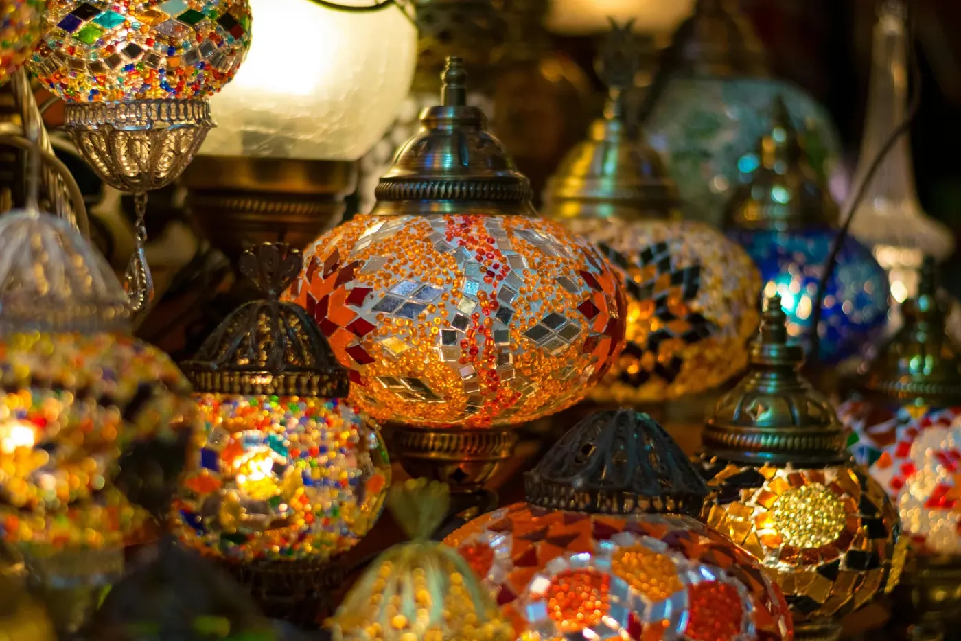 Lit mosaic lanterns hanging in a souk stall in Tunis