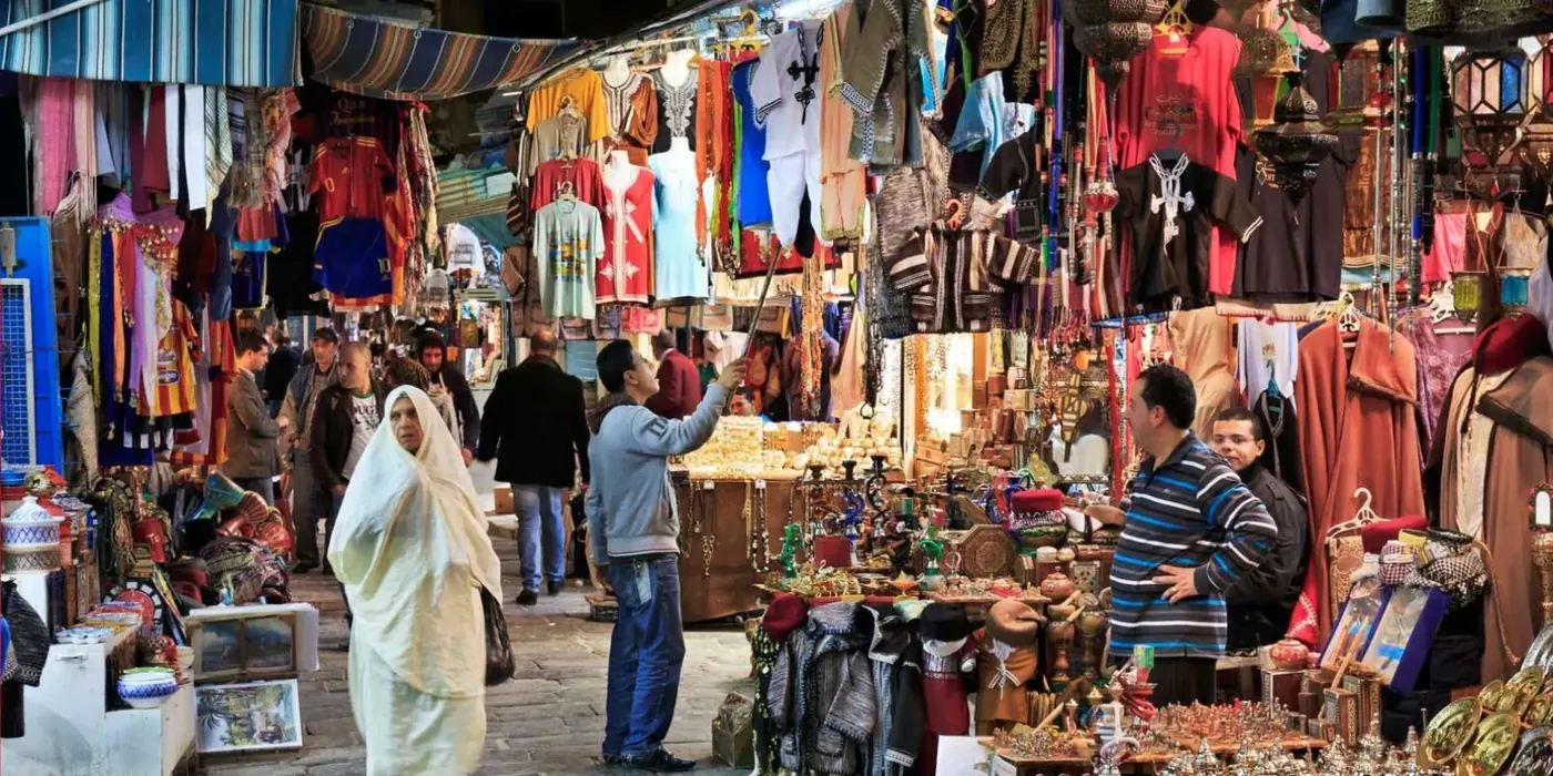Textiles and souvenirs crowding a covered souk in the Tunis medina