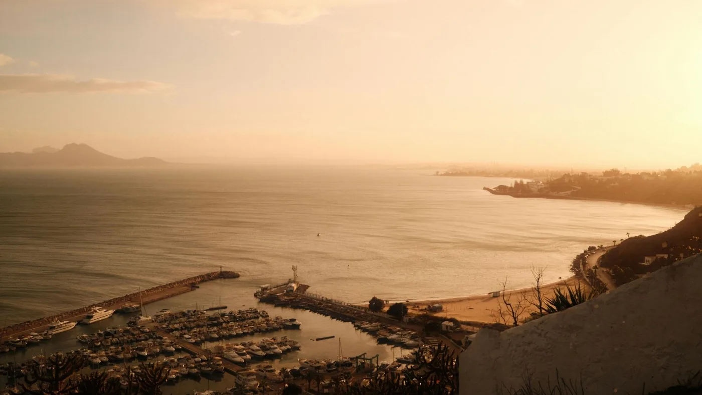 The marina below Sidi Bou Said at dusk, seen from the cliff path above the Gulf of Tunis