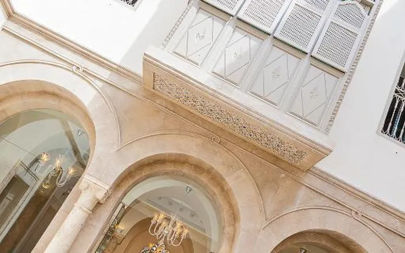 Carved white facade and arched windows of Dar El Jeld Hotel and Spa in the Medina of Tunis